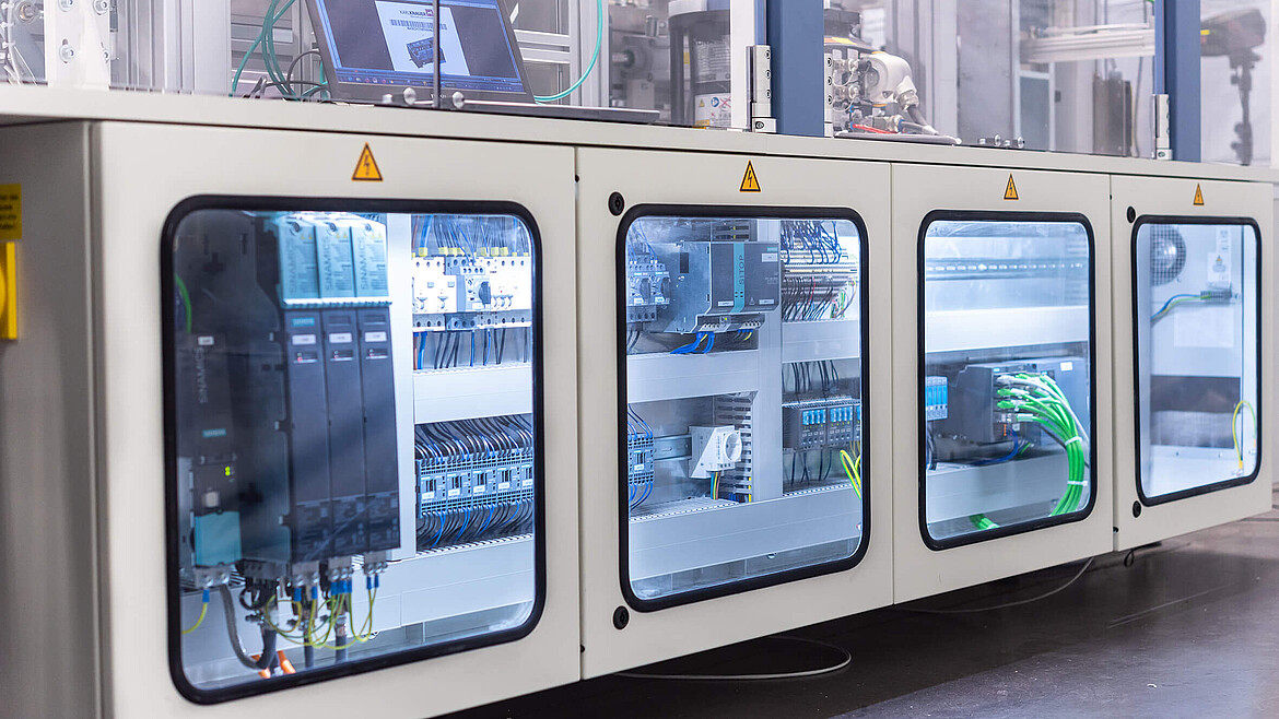 A packaging machine’s cable connections behind glass windows